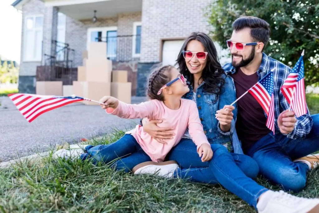 family hugging and smiling sitting on the grass with accessories from USA